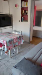 un soggiorno con tavolo e TV di Maison MICDEN a Saint-Jean-Pla-de-Corts