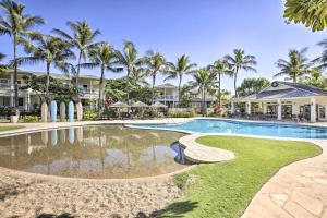 un complejo con una piscina con palmeras en el fondo en Coastal Ko Olina Townhome - Walk to Beaches! en Kapolei