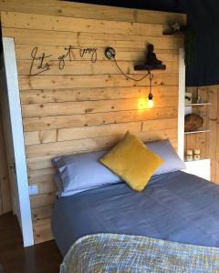 a bedroom with a wooden wall with a bed at Hilltop Hideaway - Secluded pod with private hot tub in Newry