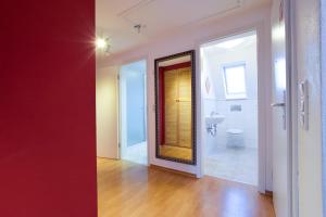 een badkamer met een rode muur en een badkamer met een toilet bij Premium Style in Günzburg