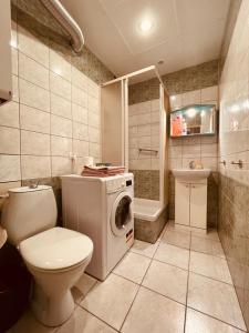 a bathroom with a toilet and a washing machine at Apartamenty KTW Park Śląski Luksusowy PRL in Katowice