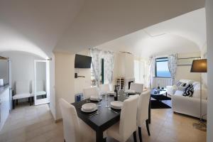 comedor y sala de estar con mesa y sillas en Villa Knight, en Amalfi