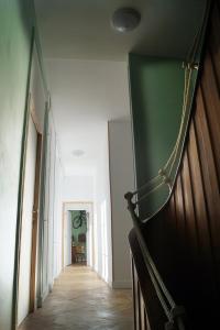 a hallway with a wooden floor and a green wall at Normand'Histoire Chambres d'Hôtes in Isigny-sur-Mer