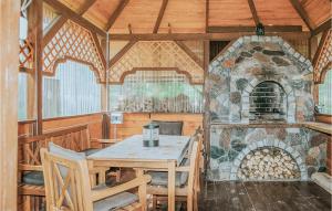 a dining room with a table and a stone oven at Beautiful Home In Wegorzewo With 3 Bedrooms, Wifi And Sauna in Trygort