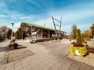 a building with a green roof with flowers in front of it at Apartamenty KTW Park Śląski Luksusowy PRL in Katowice