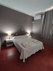 a bedroom with a bed with two tables and two lamps at Hostería de Ancasti in Ancasti