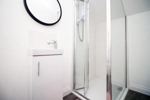 uma casa de banho com uma cabina de duche em vidro e um espelho. em The North - LONG STAY OFFER - 3 Bed Flat with Parking by CTO Serviced Apartments em Cardiff