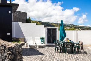 une terrasse avec une table, des chaises et un parasol dans l'établissement English house, à Ponta Delgada
