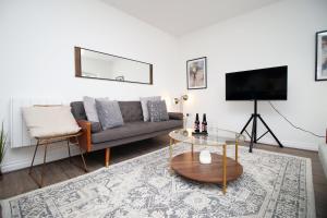 uma sala de estar com um sofá e uma televisão em The North - LONG STAY OFFER - 3 Bed Flat with Parking by CTO Serviced Apartments em Cardiff