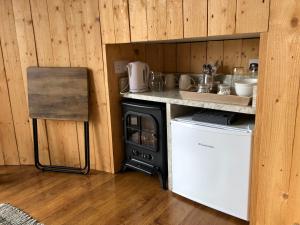 a kitchen with a stove and a counter and a dishwasher at Hilltop Hideaway - Secluded pod with private hot tub in Newry