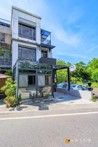 a building with a table and chairs in front of it at Harbour Enjoy Homestay in Yilan City