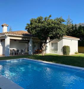 a swimming pool in front of a house at Villa Quimera en Marbella in Marbella