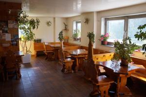 a restaurant with wooden tables and chairs and windows at Antonella's Home in Passo del Tonale