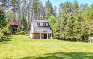 a large house on a grassy field with trees at Beautiful Home In Biskupiec With Kitchenette in Biskupiec