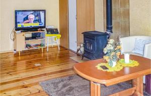 a living room with a wood stove and a tv at Beautiful Home In Biskupiec With Kitchenette in Biskupiec