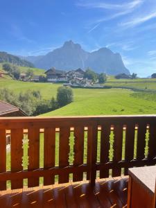a wooden bench with a view of a green field at SciliarGuestHouse-due piani parcheggio privato in Castelrotto