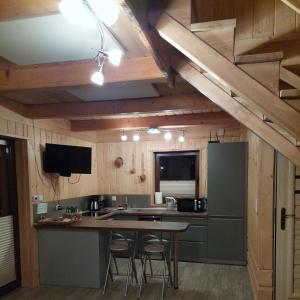 a kitchen with a table and some chairs in it at Domek Pod Tylką in Grywałd