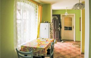 a dining room with a table and a refrigerator at Holiday Home Cekcyn Ul Lesna in Cekcyn