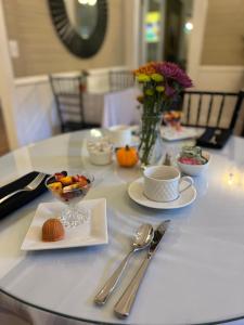 Liberty Hall Bed and Breakfast في Pendleton: طاولة عليها أطباق من الطعام والفضيات