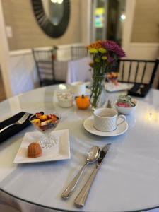 a table with plates of food and silverware on it at Liberty Hall Bed and Breakfast in Pendleton