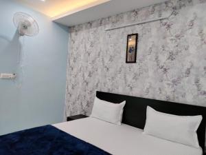 a bedroom with a bed and a wall with flowers at The Arcas Hotel in Lucknow