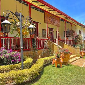 a house with a dog statue in the front yard at Hotel Hacienda Santa Barbara in San Gil