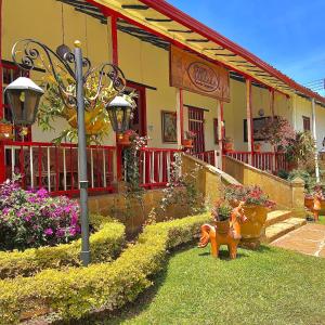 聖吉爾的住宿－Hotel Hacienda Santa Barbara，前院有狗像的房子