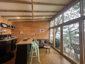 a kitchen and living room with a large window at Luxury Tiny House - Minca in Minca