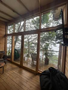 a screened in porch with a large glass door at Luxury Tiny House - Minca in Minca