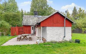 um celeiro vermelho e branco com uma mesa de piquenique e um banco em 3 Bedroom Amazing Home In Lrbro em Lärbro
