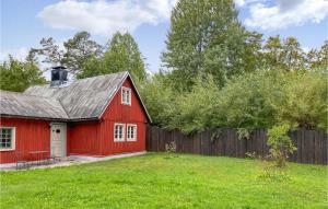 um celeiro vermelho num quintal ao lado de uma cerca em 3 Bedroom Amazing Home In Lrbro em Lärbro