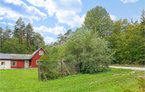um celeiro vermelho num campo ao lado de uma casa em 3 Bedroom Amazing Home In Lrbro em Lärbro