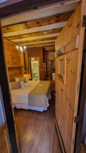 a bedroom with two beds in a room with wooden walls at Hotel Giardino Di Pietra in Gramado