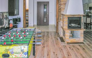 a room with a fireplace and a table with toys on it at Awesome Home In Pisz With Outdoor Swimming Pool in Pisz