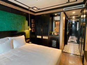 a bedroom with a large white bed and a bathroom at Hotel du Monde Classic in Hanoi