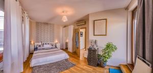 Una habitación con una cama y una planta dentro. en Budapest Top Apartment with Private 90 sqm Rooftop, Free Parking and Air Condition, en Budapest