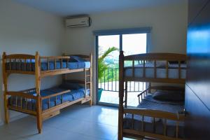 a room with three bunk beds and a balcony at City Views Apartment in San Salvador