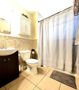 een badkamer met een toilet en een douchegordijn bij The Brick Beach House in Jacksonville Beach