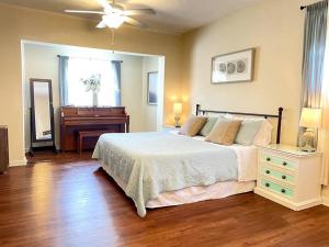 een slaapkamer met een bed, een dressoir en een piano bij The Brick Beach House in Jacksonville Beach