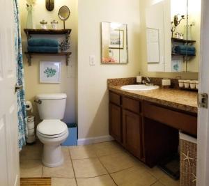 een badkamer met een wit toilet en een wastafel bij The Brick Beach House in Jacksonville Beach