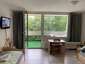 sypialnia z biurkiem, stołem i oknem w obiekcie Apartment Hannover Messe w Hanowerze