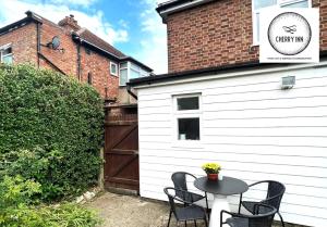 een patio met een tafel en stoelen naast een gebouw bij 3 Bedroom House with Parking & Garden By Cherry Inn Short Lets & Serviced Accommodation Cambridge in Cambridge