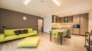 a living room with a yellow couch and a table at Chalet 4 Stagioni in Livigno