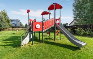 a playground with a slide in the grass at Stunning Apartment In Nidzica With Outdoor Swimming Pool, Sauna And 3 Bedrooms in Nidzica