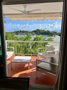 a room with a balcony with a view of the water at Marina Hill Appartement vue mer in Le Gosier