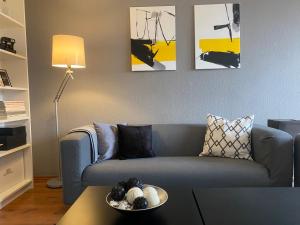 uma sala de estar com um sofá azul com pinturas na parede em NordiCasa em Eger