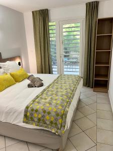 a bedroom with a bed with a yellow and gray blanket at Marina Hill Appartement vue mer in Le Gosier