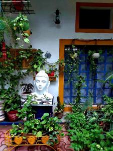 una estatua en un jardín con muchas plantas en The Coral House Homestay by the Taj, en Agra