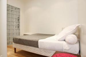 1 dormitorio con 1 cama con sábanas y almohadas blancas en JULES JO en París