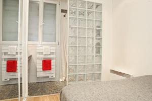 1 dormitorio con pared de cristal junto a la cama en JULES JO en París